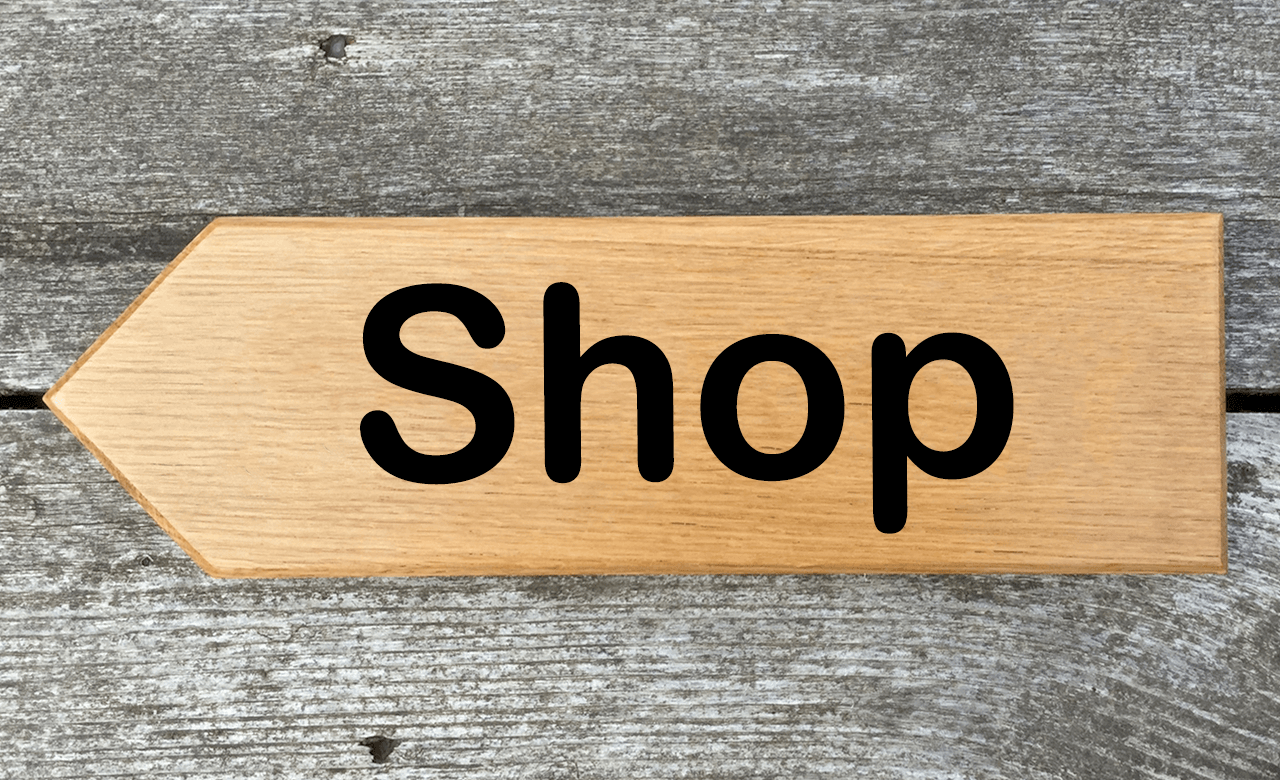 Shop directional sign pointing towards the left