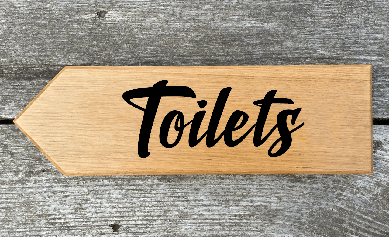 Toilets Directional Sign Pointing Towards the Left