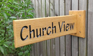 Solid oak wooden sign extruding from a solid oak backplate which is attached to the surface with four simple screw fixings, providing a 180 view, with engraved lettering painted with black paint finished with 3 coats of osmo oil.